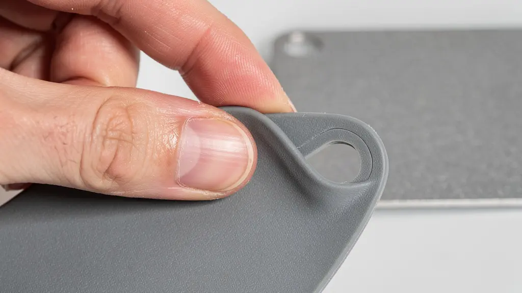 Gros plan d’une main testant la texture et la solidité d’un objet promotionnel neutre, illustrant l’importance de l’échantillon physique.